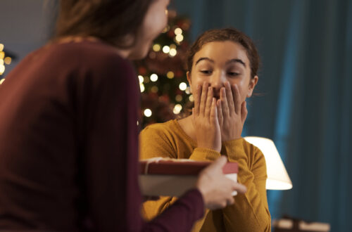 Mädchen erhält ein Weihnachtsgeschenk von ihrer Mutter