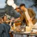 Freunde geniessen froehliche Stimmung bei Gartenparty am Abend | Terrassenüberdachung