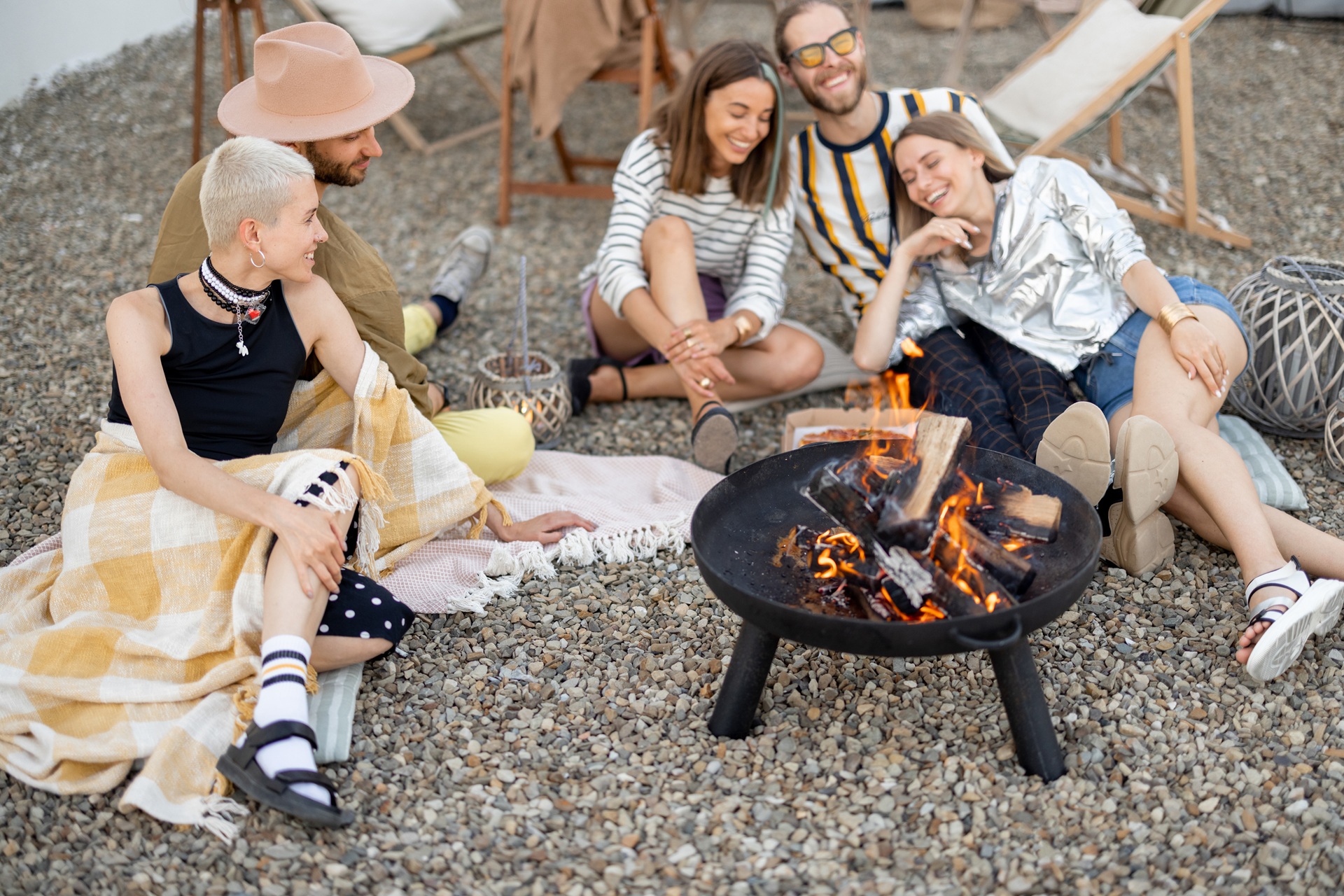 Freunde sitzen gemütlich am Lagerfeuer im Garten | Terrassenüberdachung